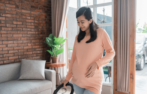 pregnant-woman-cleaning-floor-with-vacuum-cleaner 1